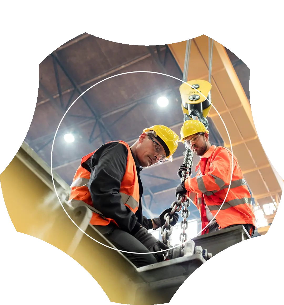 Two industrial technicians in hard hats and safety vests securing heavy crane rigging chains, framed inside a custom geometric shield cutout.